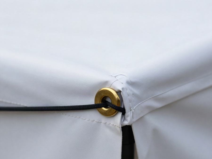 Close-up of a hemmed vinyl banner edge with a metal grommet and tie